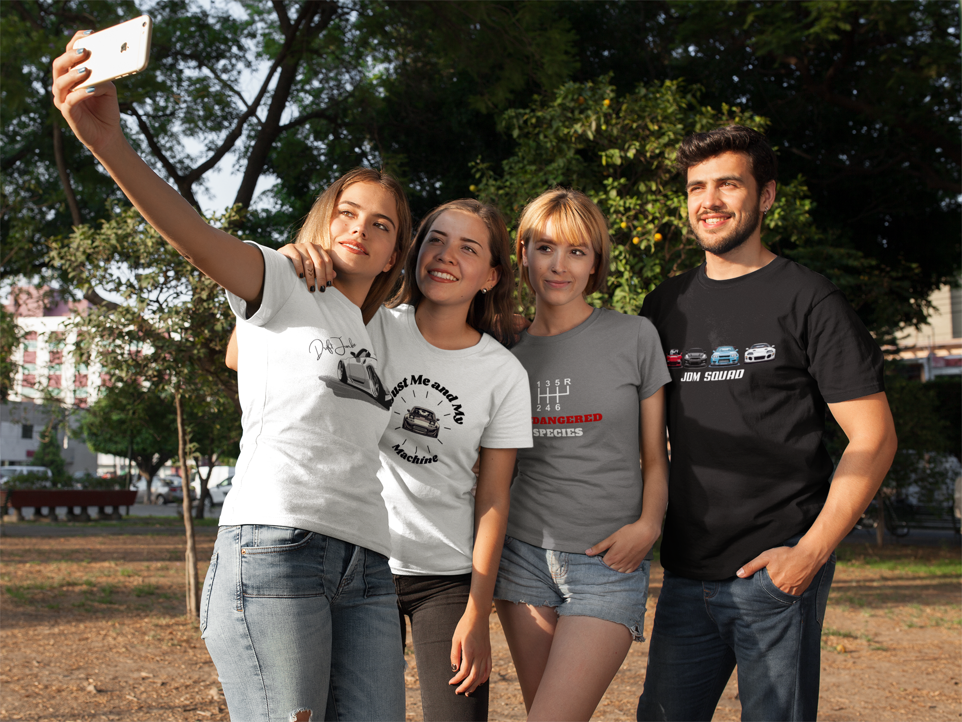 group of four friends taking a selfie at the park while wearing jdm shirts